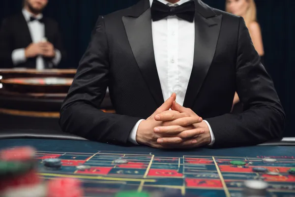 A woman in a luxurious green gown next to an ornate roulette wheel, capturing the upscale casino mood of KKBDD.